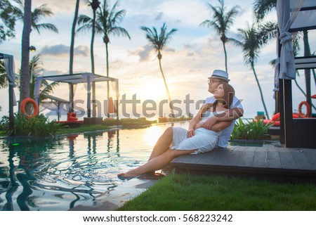 Couple on the pool at tropical resort travel concept