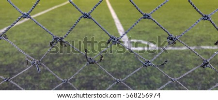 Front focus of the thin mesh fence barrier between us and the football field.