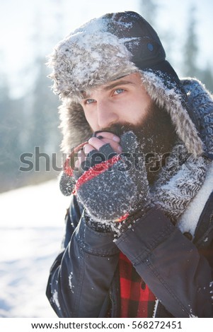 Frozen hands of man with beard