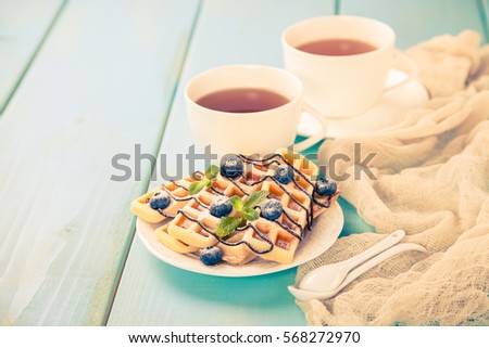 Homemade wafers with berries and tea on a table. Selective focus. Copy space. The image is tinted