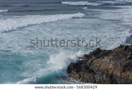 Shot of beautiful sea waves crashing on big rocks in Lanzarote island