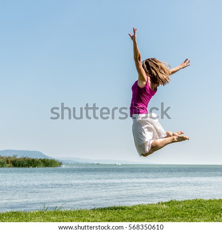 Girl jumping on the lake Bohinj. Slovenia