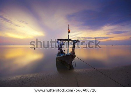 a fishing boat lies at sunrise in thailand