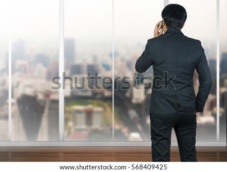 Attractive businessman using a cellphone on a modern office
