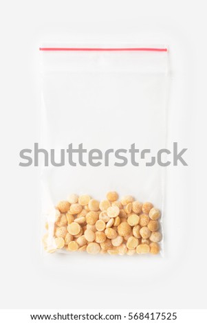 Plastic transparent zipper bag with a little raw organic split peasisolated on white, Vacuum package mockup with red clip. Concept Royalty-Free Stock Photo #568417525