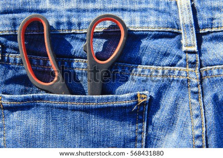 Pair of scissors in the pocket of blue jeans