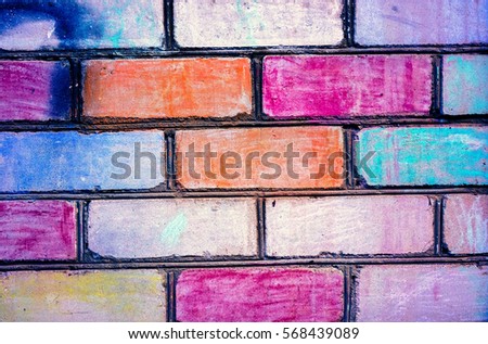 Bricks painted to rainbow color on brickwall. Colorful brick wall pattern, painted bricks as urban texture. Children painted white brick wall to different colors. Brickwall as example of children art