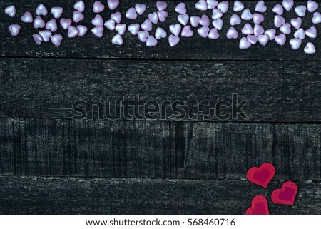 small purple and red hearts on dark wooden table. Valentines Day concept