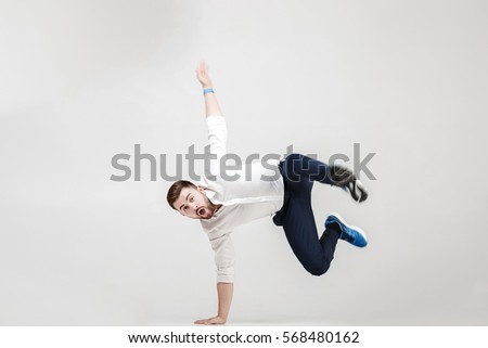young happy businessman with beard in shirt break dancing on gre