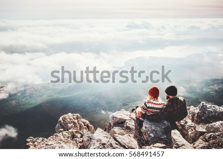 Couple travelers Man and Woman sitting on cliff relaxing mountains and clouds aerial view  Love and Travel happy emotions Lifestyle concept. Young family traveling active adventure vacations Royalty-Free Stock Photo #568491457