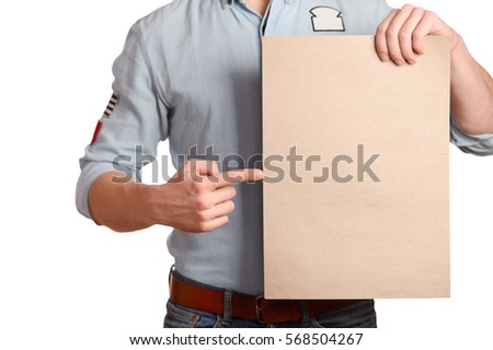 Stylish man in a light denim shirt indicates a blank sheet which holds a