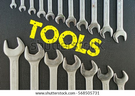 concept picture: wrench on a black background with the word (TOOLS)