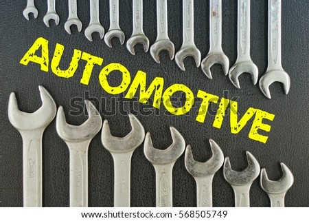 concept picture: wrench on a black background with the word (AUTOMOTIVE)