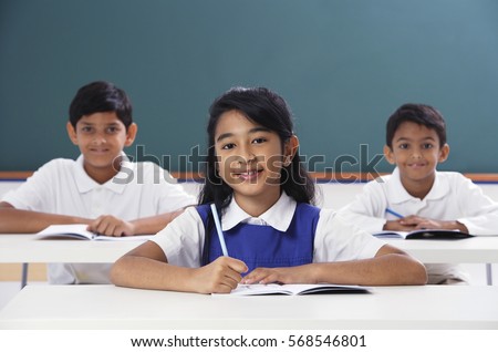 three students smile at camera, girl in center