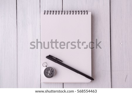 Note book,glasses,pen,compass,coffee on wooden desk.top view.travel concept.