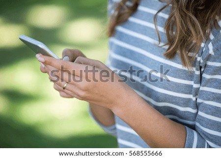 Close-up of hands using a smartphone in a park