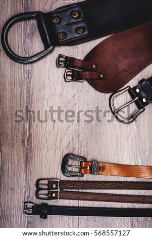 leather belts in wooden background