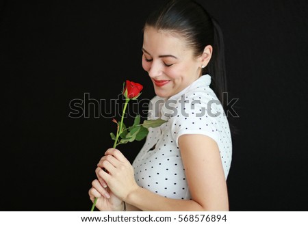 A beautiful young woman receives a rose from a significant other, possibly for Valentine's Day.