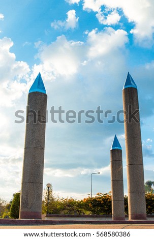 Cement poles tipped sky background.