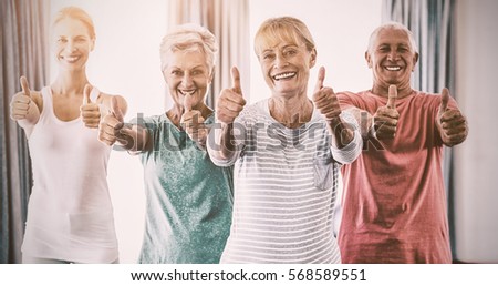 Portrait of instructor and seniors with thumbs up in studio