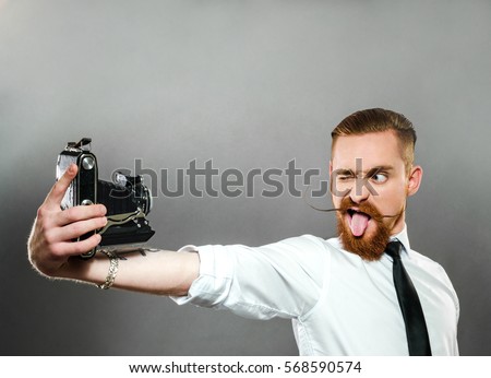 stylish the guy with the beard shows language and makes selfie