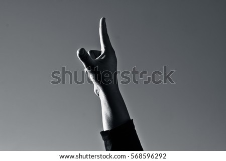 Human hand pointing finger towards sky.