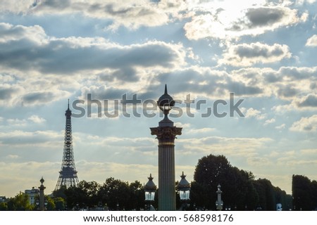 cloudy sky over Paris with Eiffel Tower, with column lamp and lights of Place de la Concorde in foreground