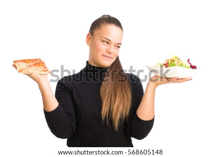 Young woman holding a slice of pizza and plate with salad, isolated against white background.