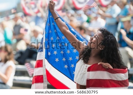 Girl at rally holding up american flag