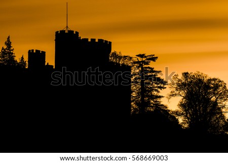 Spooky silhouette of a castle and trees with orange sky
