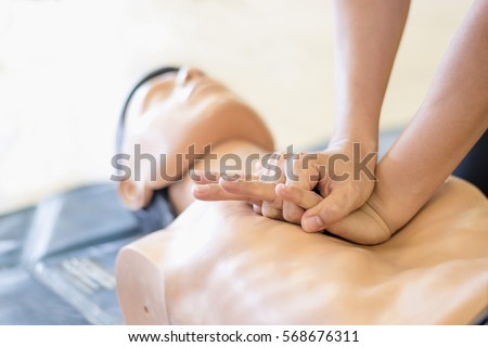CPR training medical procedure - Demonstrating chest compressions on CPR doll in the class  Royalty-Free Stock Photo #568676311