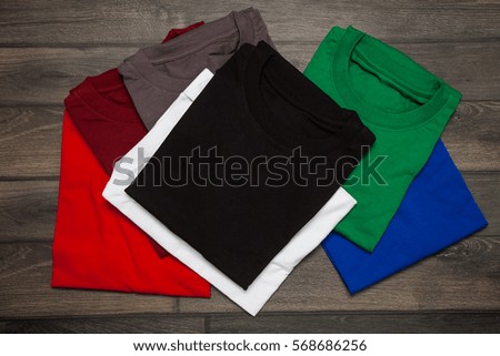 T-shirt on wooden background. Top view.