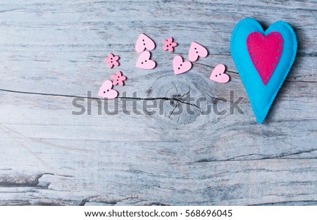 Hand made felt colorful heart on wooden background with copy space. Craft element for Valentine's Day romantic greeting card.