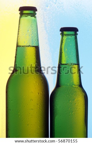 Two beer bottles on a colour background