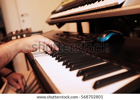 Man playing keyboards, just hand in frame and two electronic keyboards