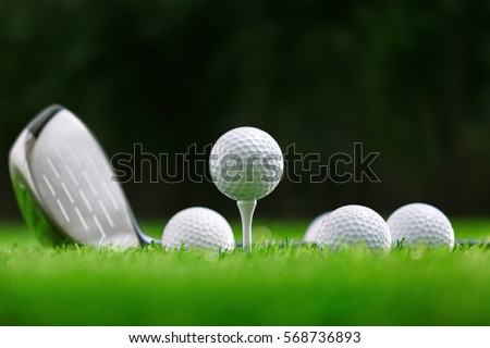 Golf balls and golf club on green grass Royalty-Free Stock Photo #568736893