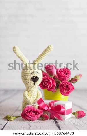 Little bunny with gift and pink roses on white background