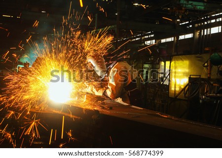 Welder arc Gouging carbon electrode rods   with sparks and smoke in  factory