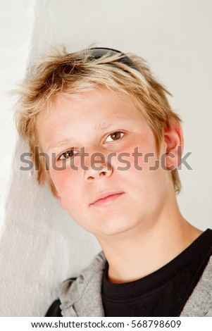 Portrait of teenage boy leaning against white wall