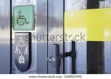 Call on glass front door of building and plaque with image of disabled person in wheelchair and people with walking stick