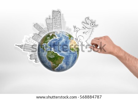 Man's hand holding cartoon funny monster going to attack city put around the globe on. Ecology and Urbanization. Creativity and art. Fantasy and science fiction. Elements of this image are furnished