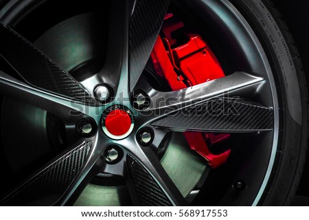 Closeup of beautiful Large Alloy wheel of expensive supercar having painted break callipers and large disc brake 
 Royalty-Free Stock Photo #568917553