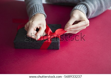 A woman wrapping a gift box