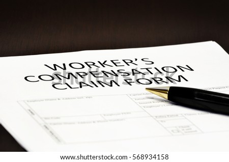 Worker's compensation claim form application with pen on desk Royalty-Free Stock Photo #568934158