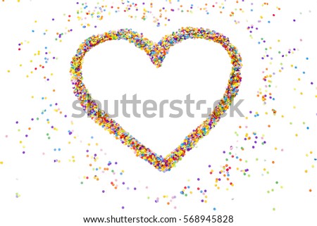 Heart made of colored confetti. Small circles of colored paper. White background. View from above. Colored heart.