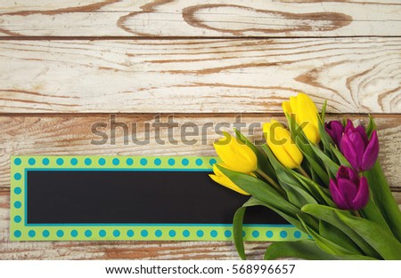 Yellow and purple tulips on wooden background