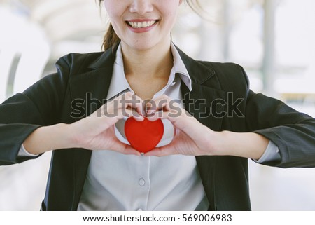 Red heart in woman hand smile,Red ball heart in Asian woman hand healthy concept