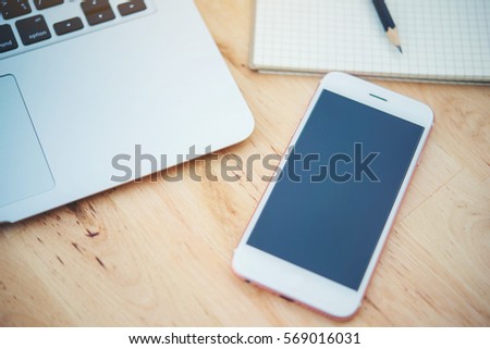 smartphone and laptop on wooden table