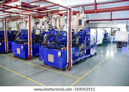 Row of plastic injection machines at empty clean workshop Royalty-Free Stock Photo #569042911