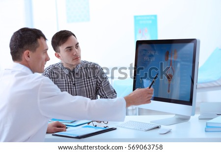 Medical concept. Doctor showing results of urology diagnostic on computer monitor Royalty-Free Stock Photo #569063758
